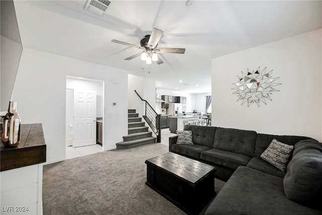 carpeted living room with ceiling fan