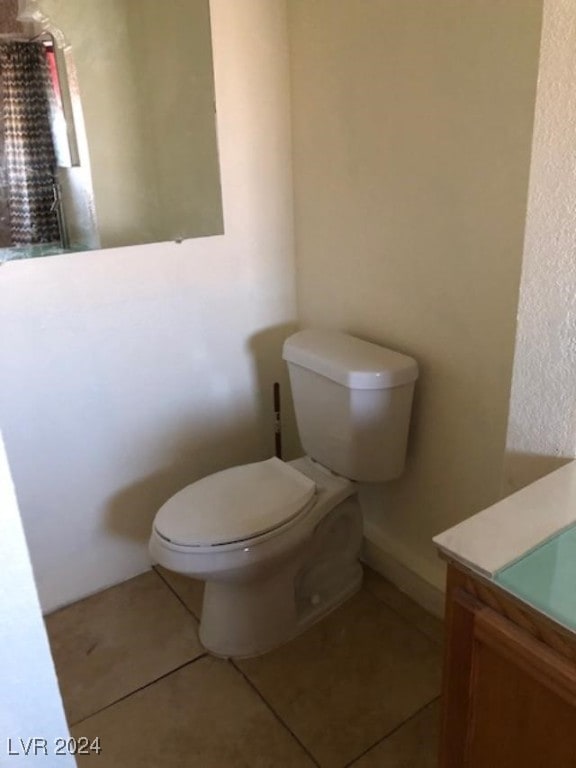 bathroom featuring vanity, tile patterned flooring, and toilet