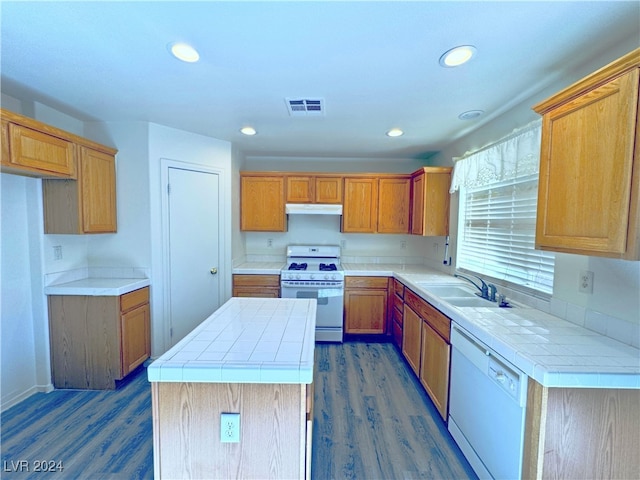 kitchen featuring tile countertops, dark hardwood / wood-style flooring, white appliances, and a center island