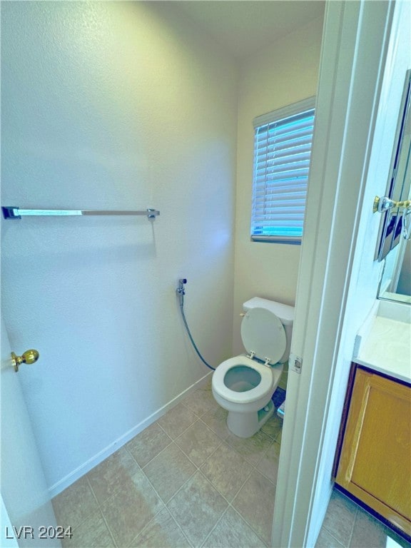 bathroom with tile patterned flooring, vanity, and toilet