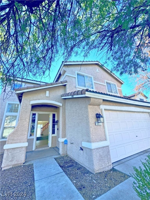 view of property with a porch and a garage