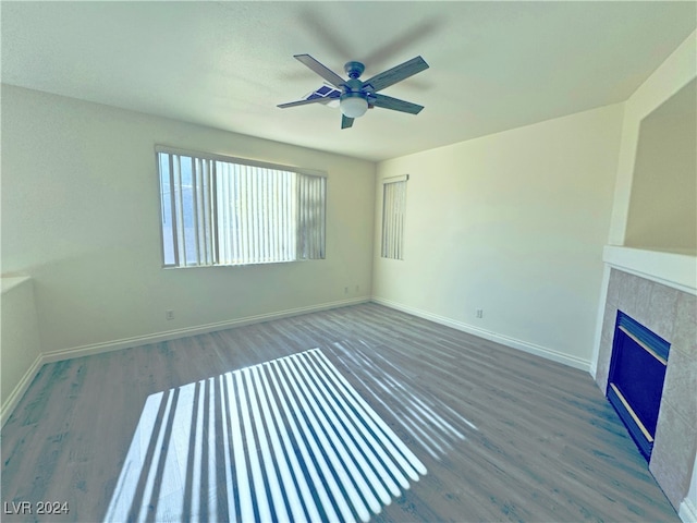 unfurnished living room with ceiling fan and dark hardwood / wood-style flooring