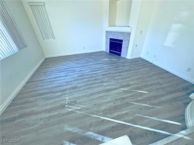 unfurnished living room with a tile fireplace and dark hardwood / wood-style flooring