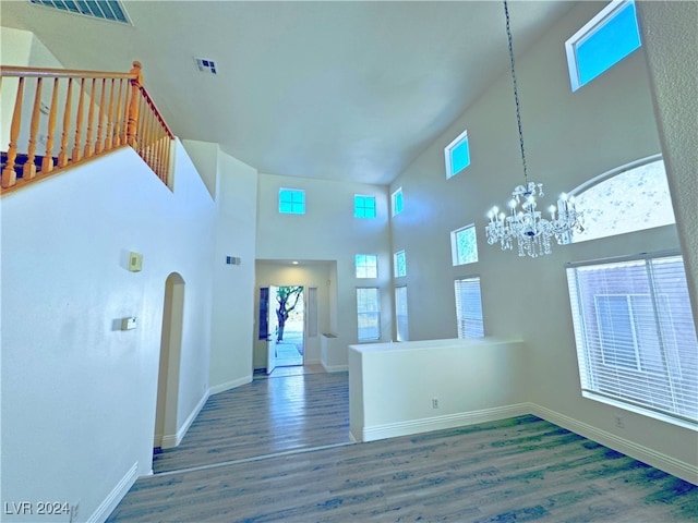 interior space with a chandelier, dark wood-type flooring, and a high ceiling