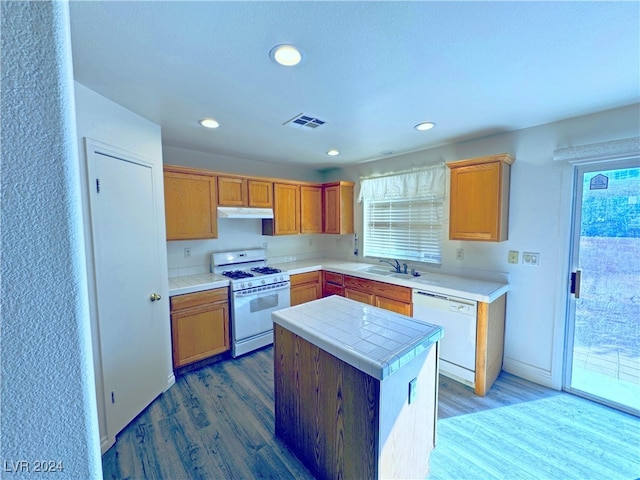 kitchen featuring plenty of natural light, a center island, white appliances, and hardwood / wood-style flooring