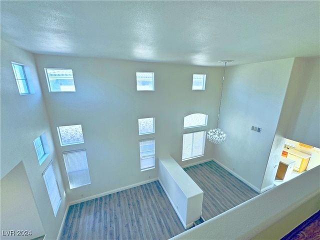 staircase featuring hardwood / wood-style floors, a textured ceiling, and a wealth of natural light