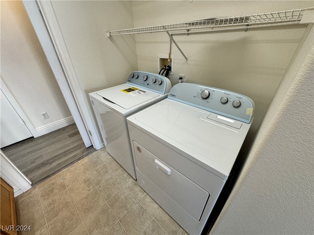 washroom with light hardwood / wood-style flooring and washer and dryer