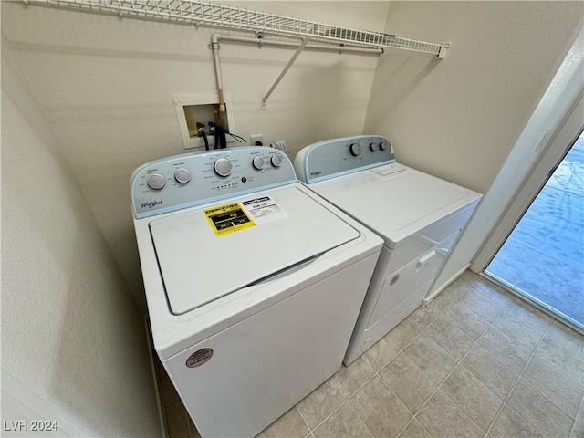 clothes washing area with light tile patterned floors and washing machine and dryer