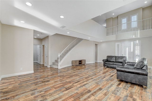 living room featuring a towering ceiling and light hardwood / wood-style floors