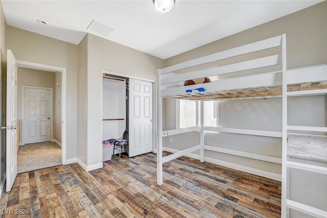 unfurnished bedroom with dark hardwood / wood-style flooring and a closet