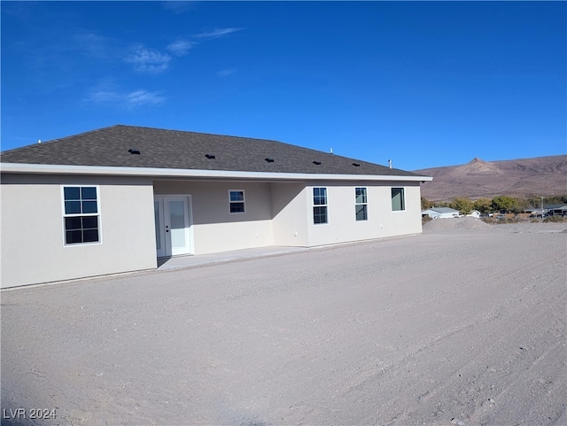 rear view of house featuring a patio area and a mountain view