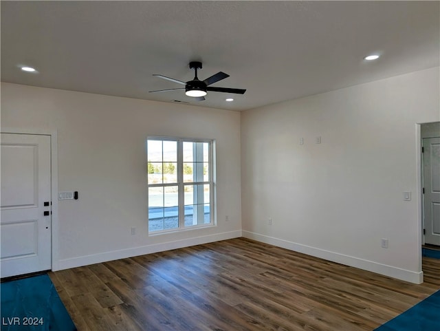 spare room featuring ceiling fan and dark wood-type flooring