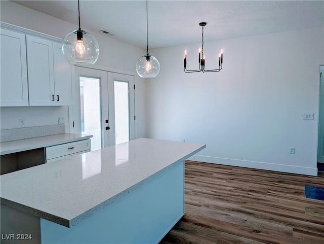 kitchen with an inviting chandelier, decorative light fixtures, dark hardwood / wood-style flooring, a kitchen island, and white cabinets