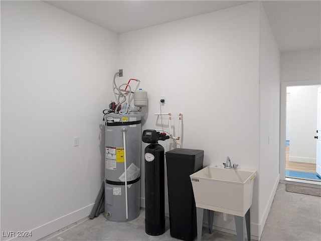 utility room with sink and strapped water heater