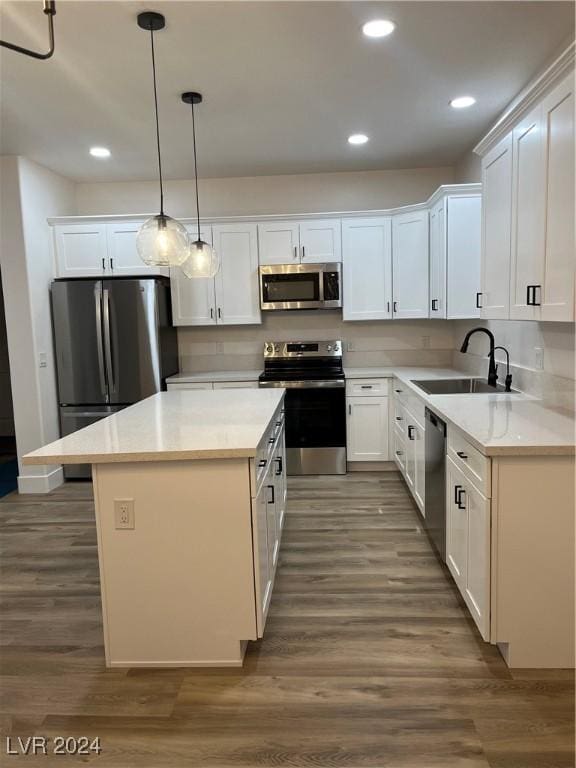 kitchen featuring white cabinetry, appliances with stainless steel finishes, sink, hanging light fixtures, and a center island