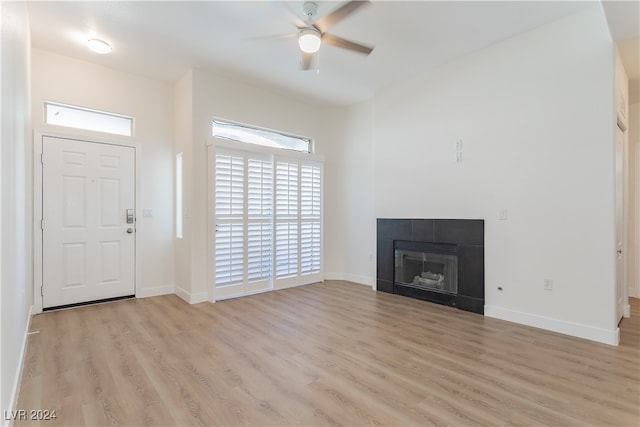 unfurnished living room with light wood-type flooring, a fireplace, and ceiling fan