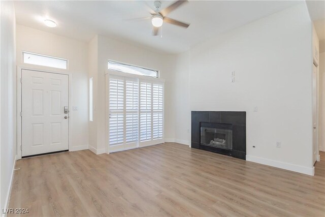 700 Carnegie St Unit 2312, Henderson, NV 89052 - unfurnished living room featuring light wood-style flooring, a ceiling fan, baseboards, and a fireplace
