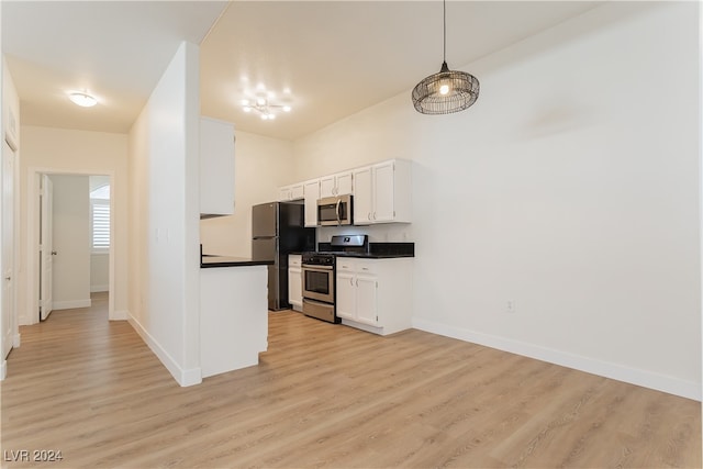 kitchen featuring pendant lighting, white cabinetry, appliances with stainless steel finishes, and light hardwood / wood-style floors