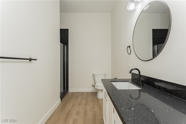 bathroom with walk in shower, wood-type flooring, toilet, and vanity