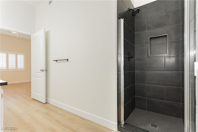 bathroom featuring hardwood / wood-style flooring and a tile shower