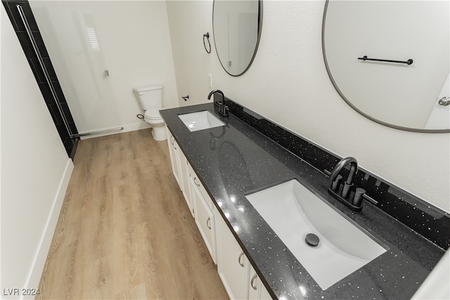 bathroom with toilet, vanity, and hardwood / wood-style flooring