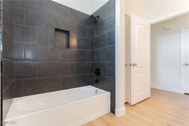 bathroom featuring wood-type flooring and tiled shower / bath