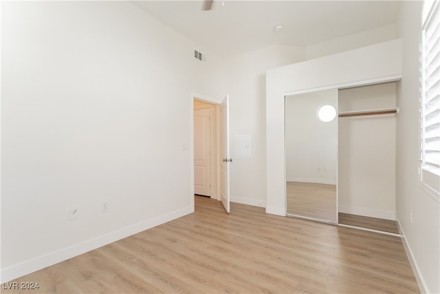 unfurnished bedroom with light hardwood / wood-style flooring and a closet