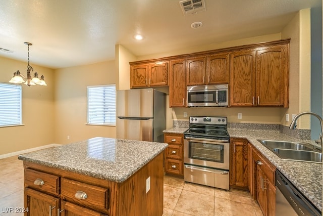 kitchen with stainless steel appliances, decorative light fixtures, light tile patterned floors, sink, and a chandelier