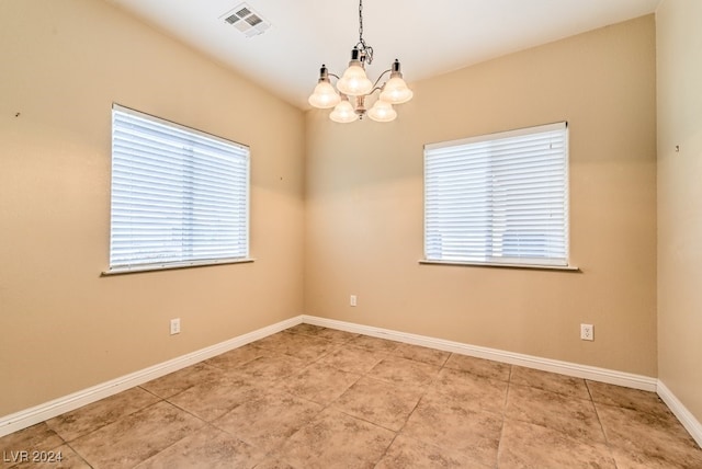 unfurnished room with an inviting chandelier