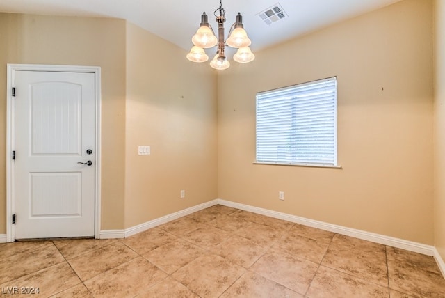 spare room featuring a notable chandelier