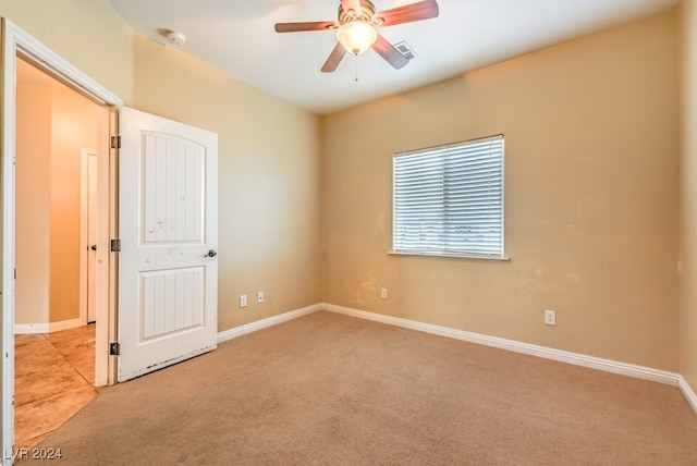 spare room with light colored carpet and ceiling fan