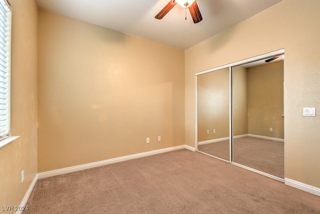 unfurnished bedroom featuring a closet, carpet, and ceiling fan