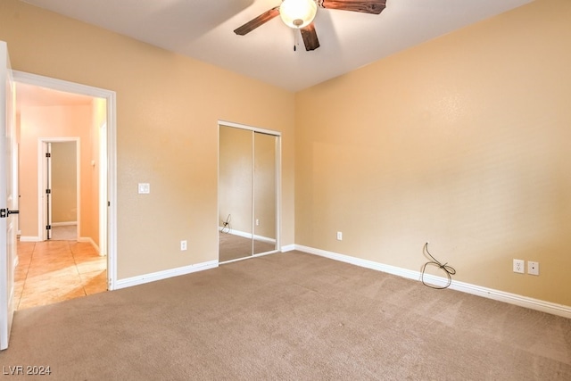 unfurnished bedroom with ceiling fan, a closet, and light colored carpet