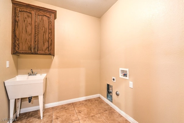 laundry room featuring cabinets, washer hookup, a textured ceiling, electric dryer hookup, and hookup for a gas dryer