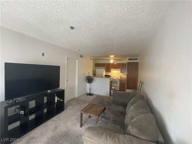 living room featuring a textured ceiling, ceiling fan, visible vents, and light colored carpet