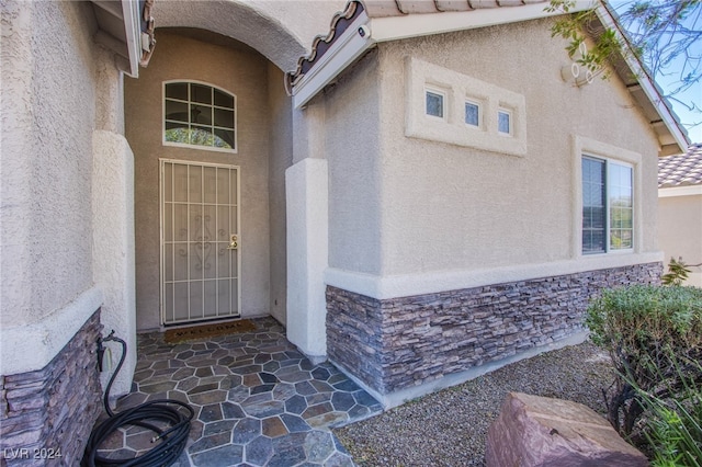 view of exterior entry featuring a patio area