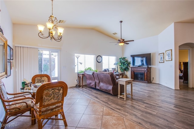 tiled dining area featuring lofted ceiling and ceiling fan with notable chandelier