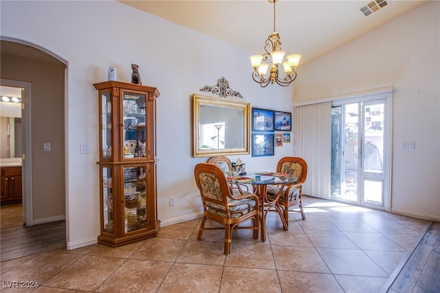 tiled dining area with vaulted ceiling and a notable chandelier