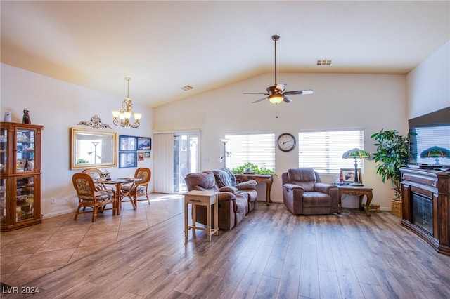 living room with hardwood / wood-style flooring, vaulted ceiling, and ceiling fan with notable chandelier