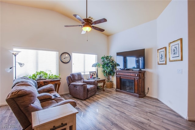 living room featuring ceiling fan, lofted ceiling, and light hardwood / wood-style flooring