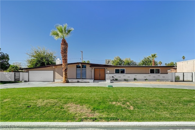 view of front of home with a front yard and a garage