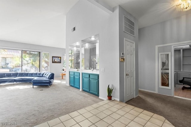 carpeted living room featuring high vaulted ceiling and sink