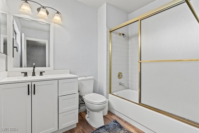 full bathroom featuring wood-type flooring, shower / bath combination with glass door, vanity, and toilet