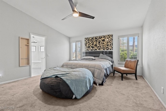 carpeted bedroom with ceiling fan, connected bathroom, and vaulted ceiling