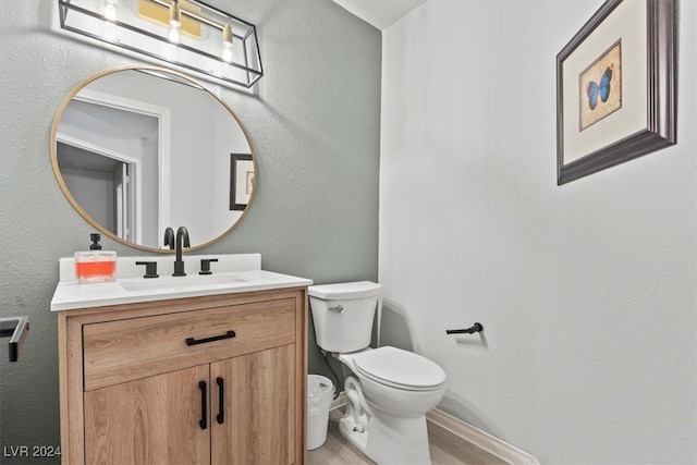 bathroom with toilet, wood-type flooring, and vanity