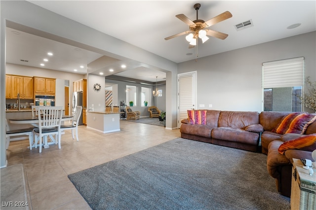 living area featuring visible vents, ceiling fan with notable chandelier, recessed lighting, light tile patterned floors, and baseboards