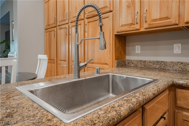 details with a sink and light stone countertops