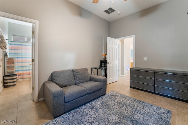 living room featuring light tile patterned flooring, visible vents, a ceiling fan, and baseboards