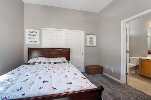 bedroom featuring a closet, ensuite bathroom, baseboards, and carpet floors