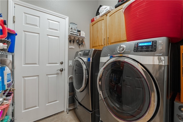 laundry room with light tile patterned floors, cabinet space, and separate washer and dryer